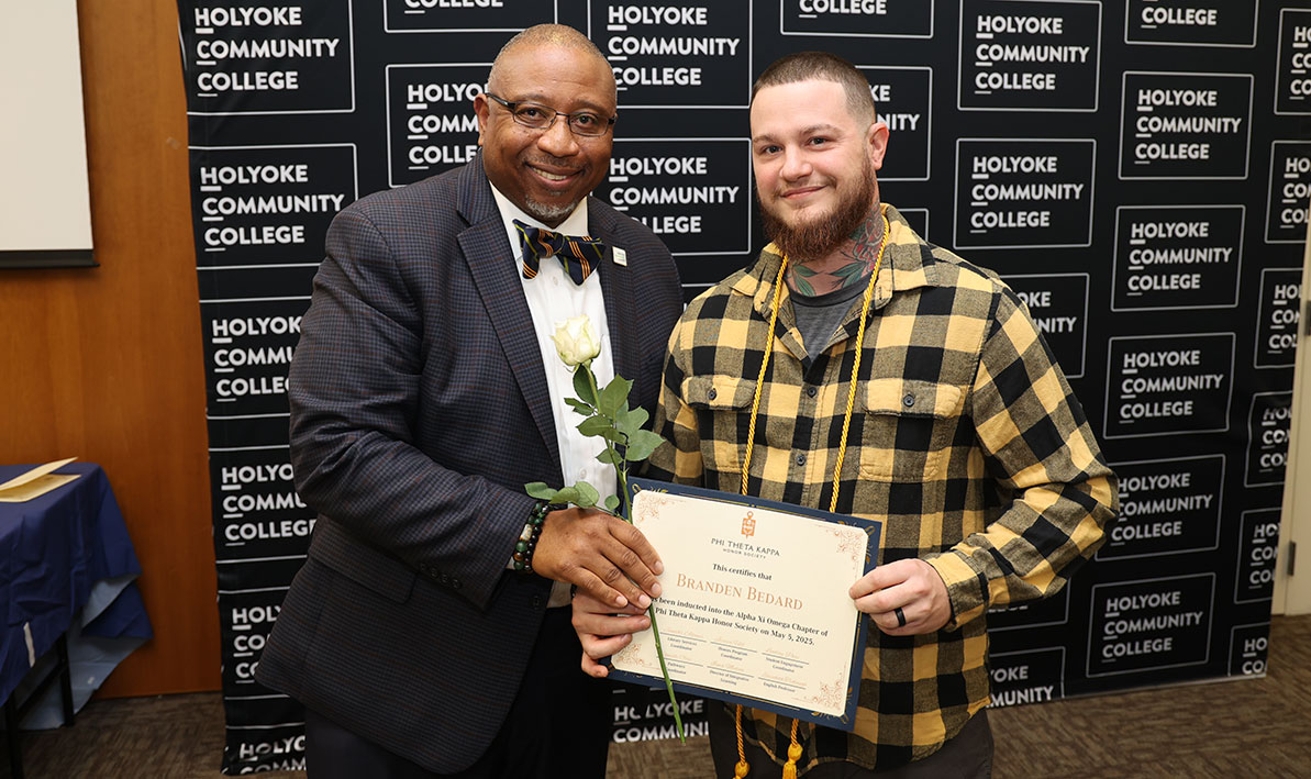 President George Timmons congratulates Branden Bedard on his induction into the Phi Theta Kappa Honor Society.